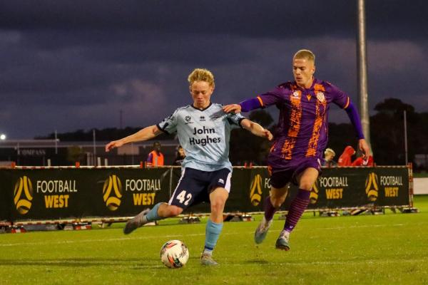 Sorrento's Clay Gibbs looks to cross as Danny Douglas closes down. Photo by FootballWest/Sheldon Nouchy